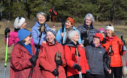 Gruppe med eldre kvinner som står ute i naturen, flere med gåstaver
