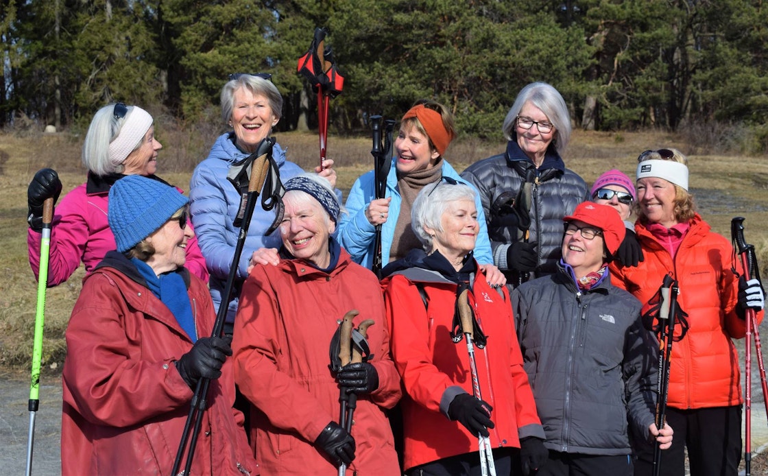 Gruppe med eldre kvinner som står ute i naturen, flere med gåstaver