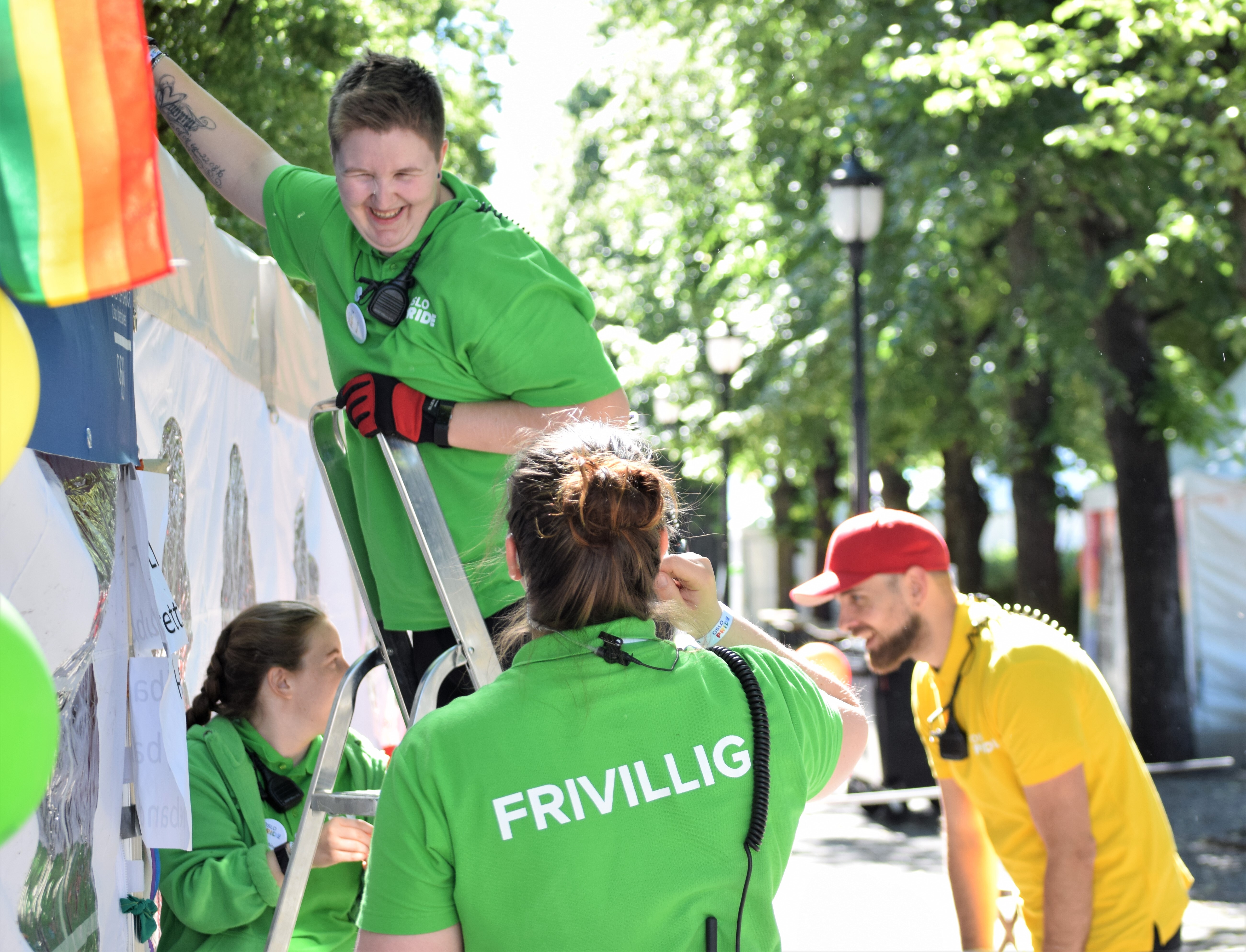 En gruppe frivillige rigger ned et arrangement, henvendt mot hverandre og smiler.