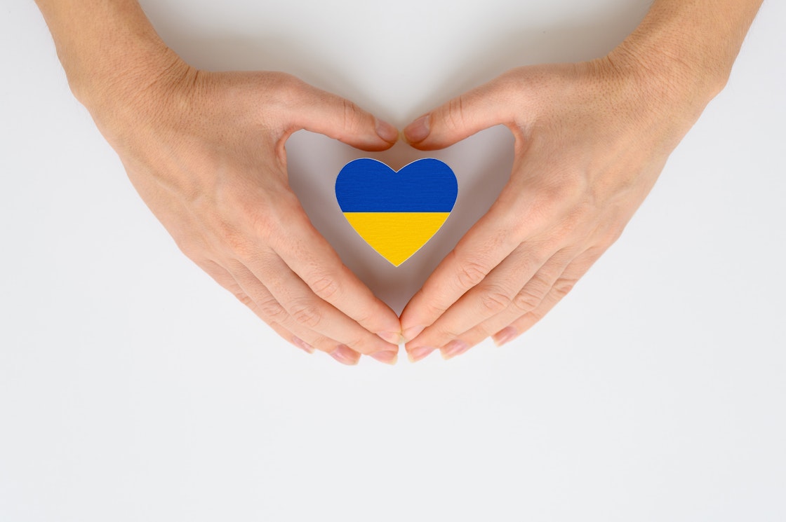 Hender rundt hjerte med ukrainsk flagg