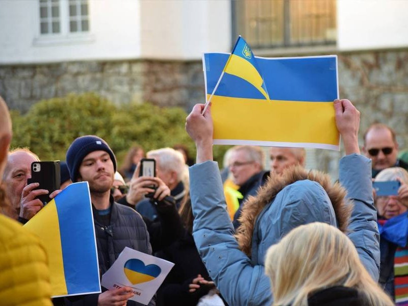 Bilde av gruppe med personer som holder opp ukrainsk flagg