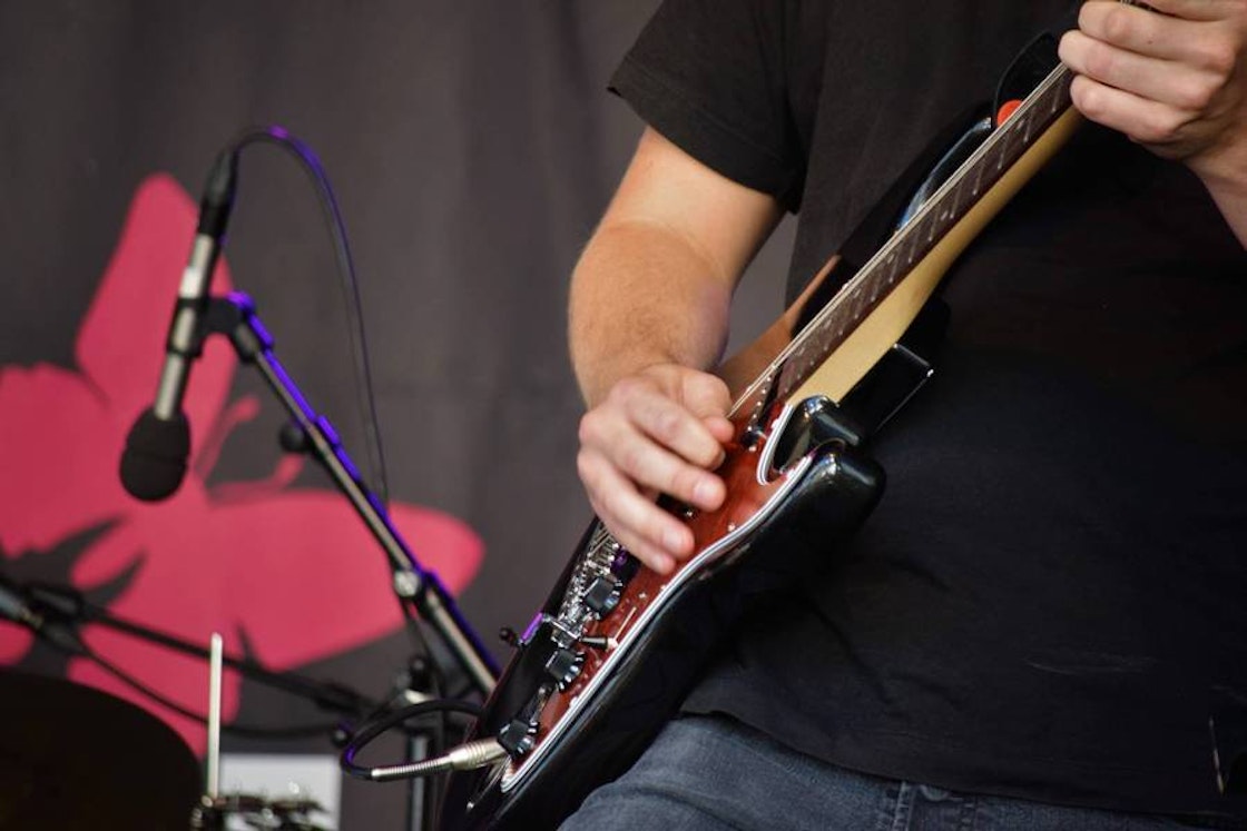 bilde av hender som spiller på en elgitar
