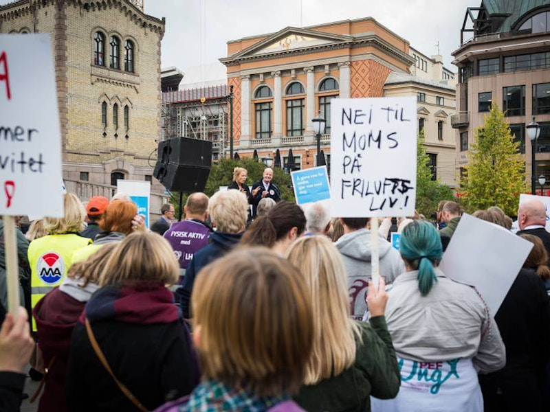 Folkemengde foran Stortinget. plakater blant annet med påskrift: Nei til moms på friluftsliv